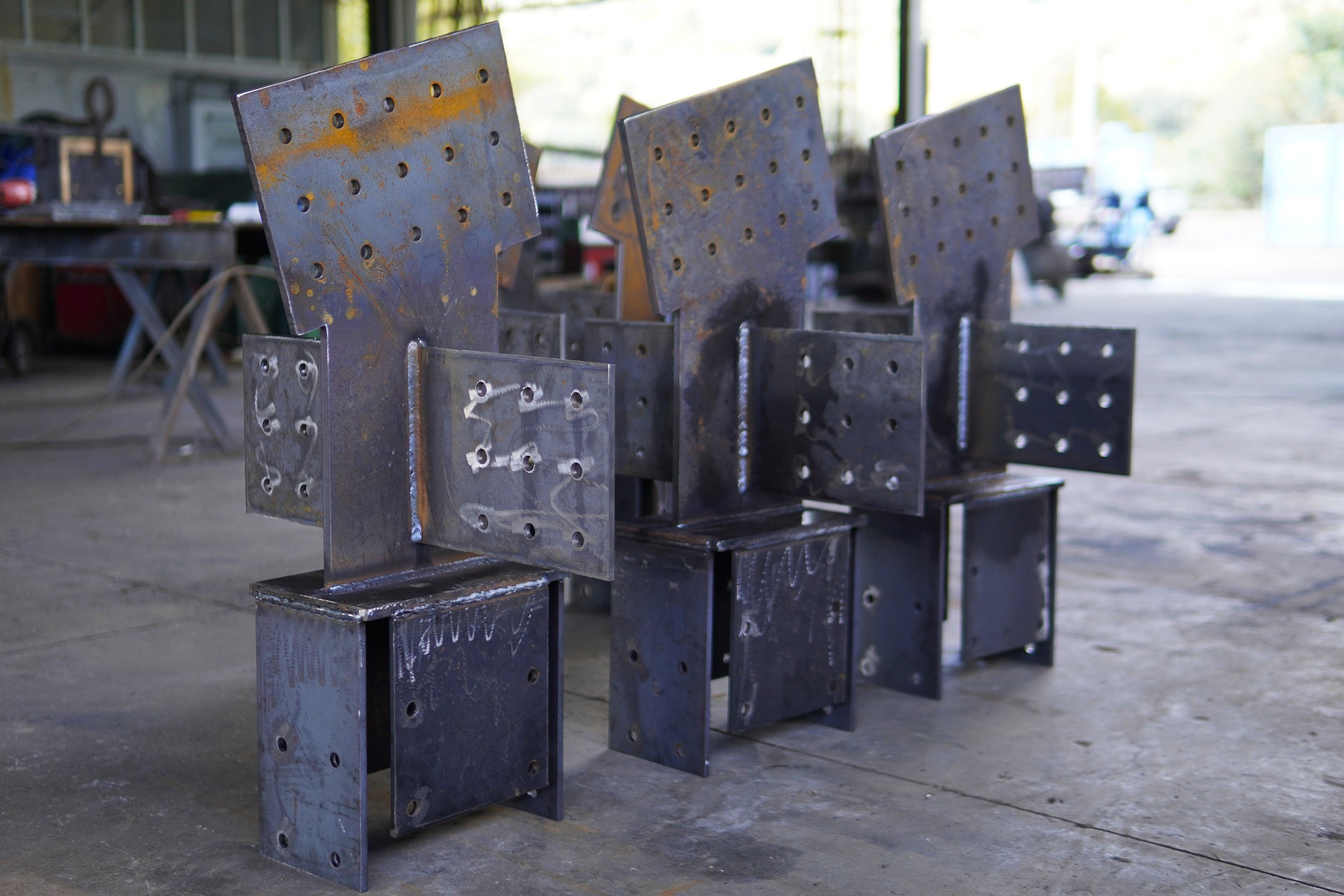 Steel structures, metalwork, and welding. Large steel components in an industrial workshop. Structural steel with welded joints and bolt holes.